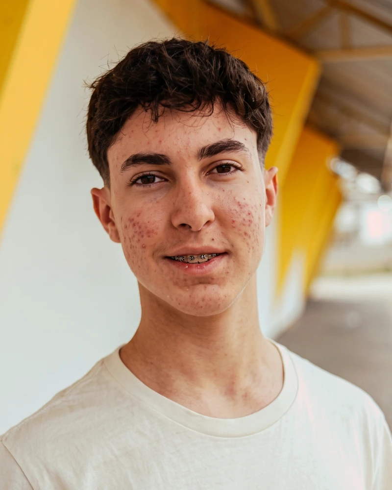 Retrato de un chico joven con el pelo corto sin trabajar y camiseta blanca